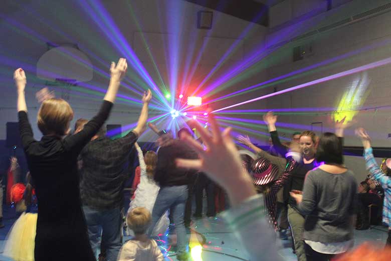 School Light Show, Hamilton DJ, Family Dance Dancers doing the YMCA with hands up light show light show in background. Taken in Hamilton Ontario.